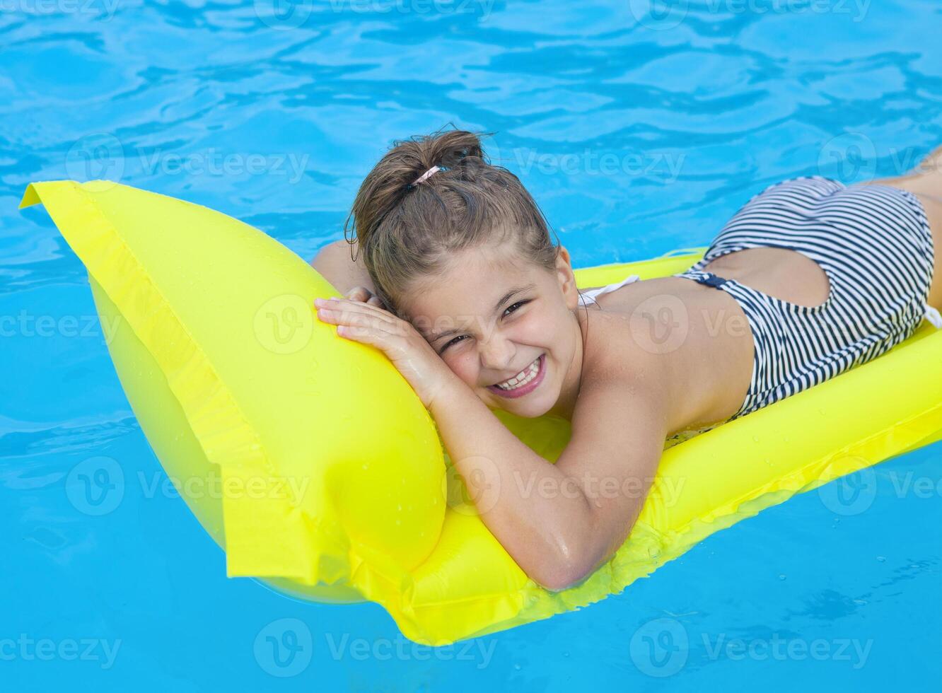 Little girl swimming on inflatable beach mattress photo