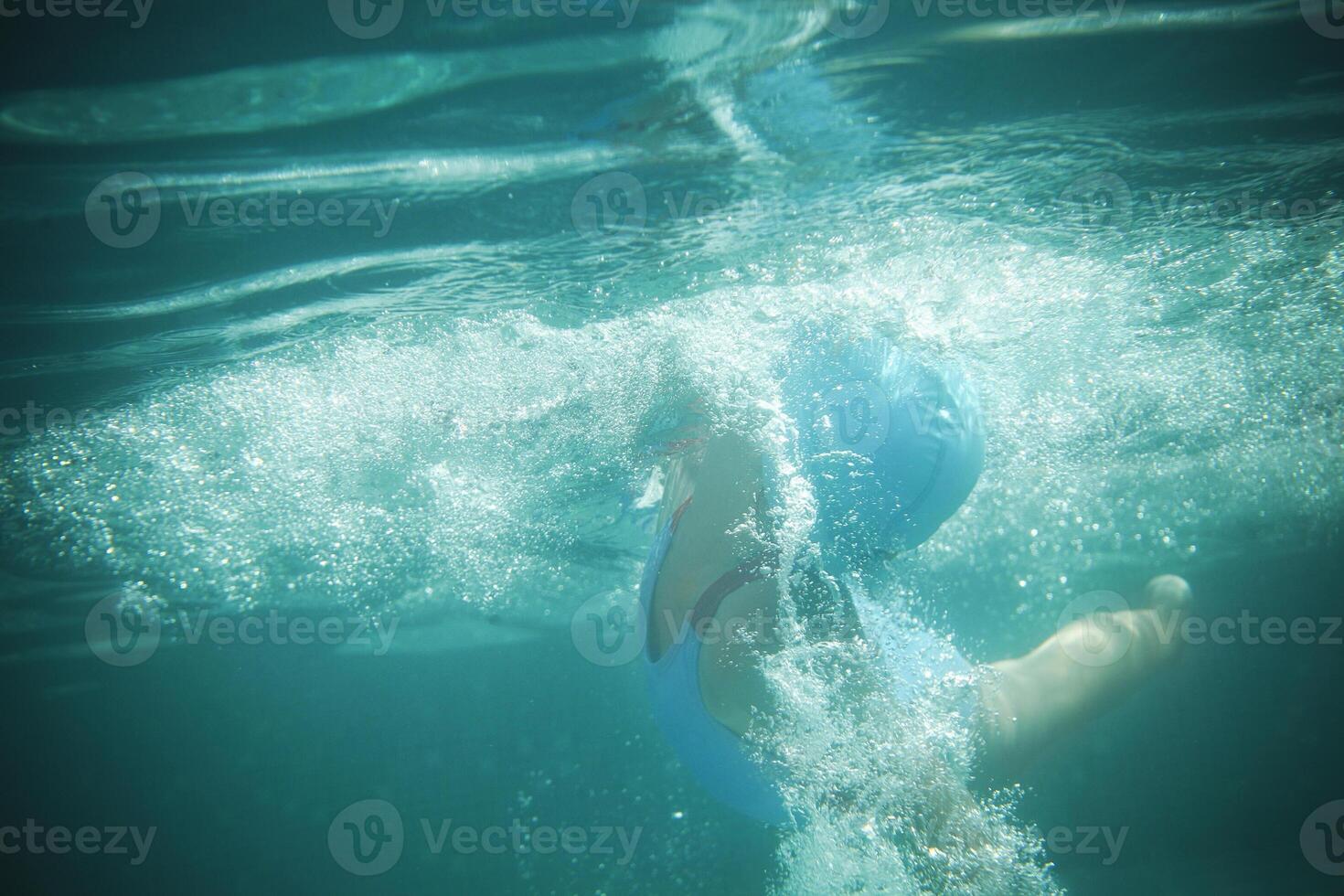 Little girl swims in the pool underwater photo