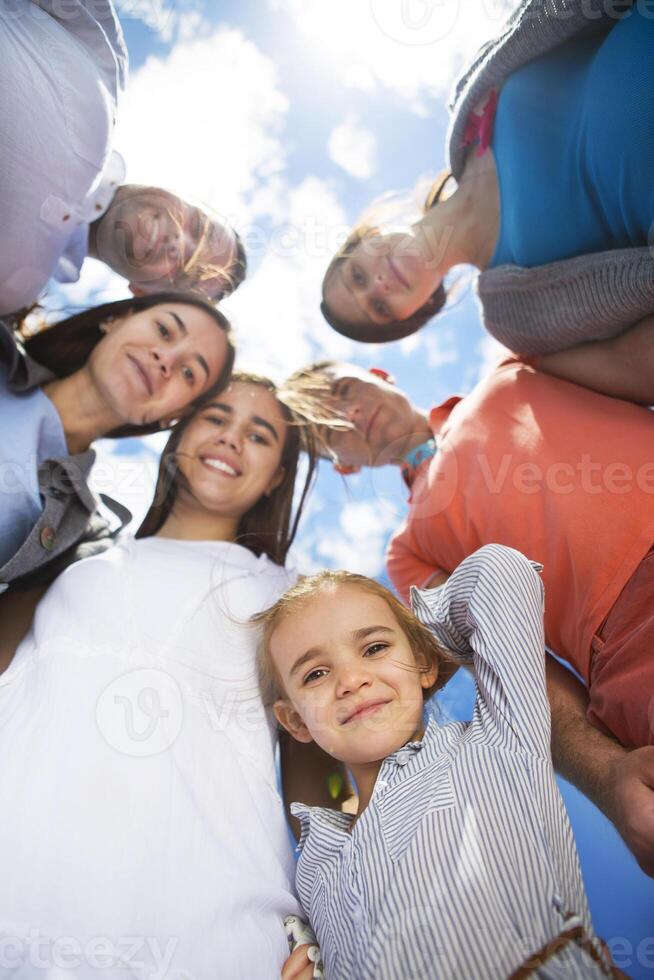 Group of happy smiling friends against blue sky photo