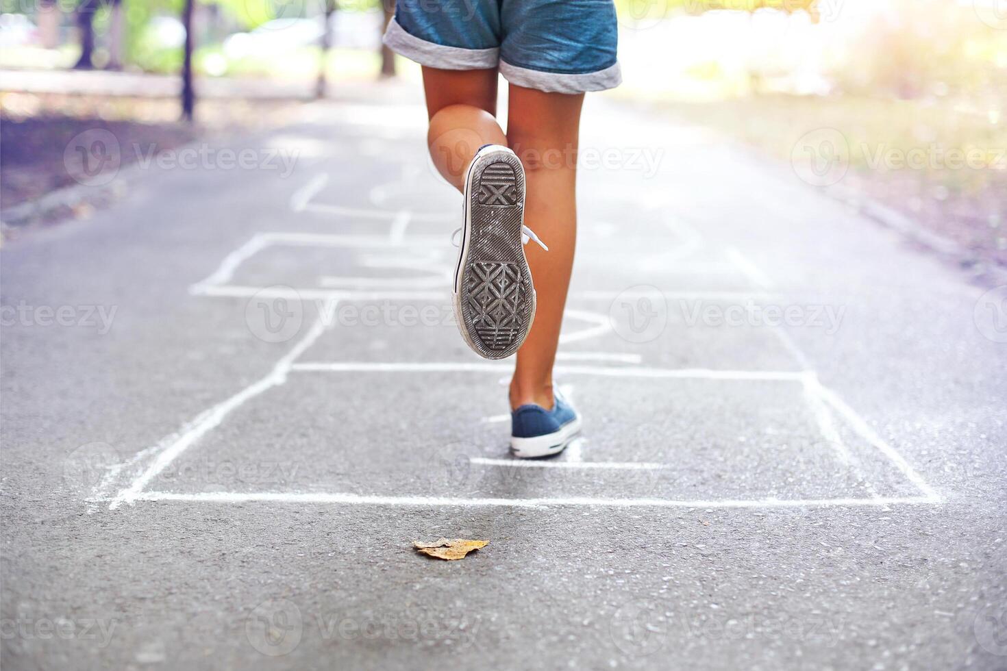 Kid playing hopscotch on playground outdoors photo