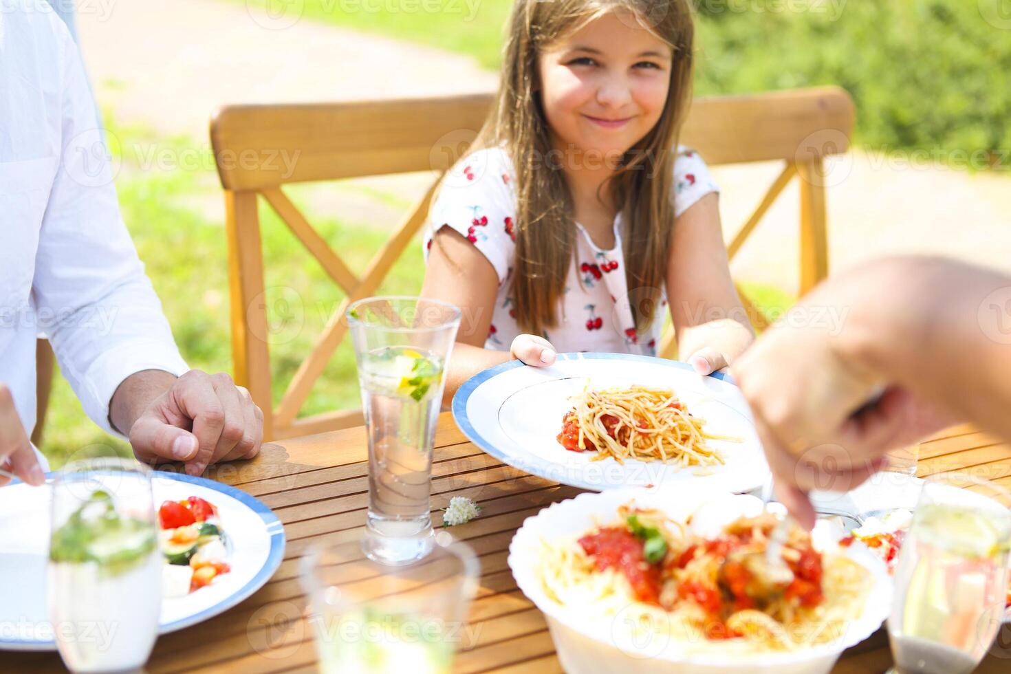 Dinner variety of Italian dishes on wooden table in the garden photo