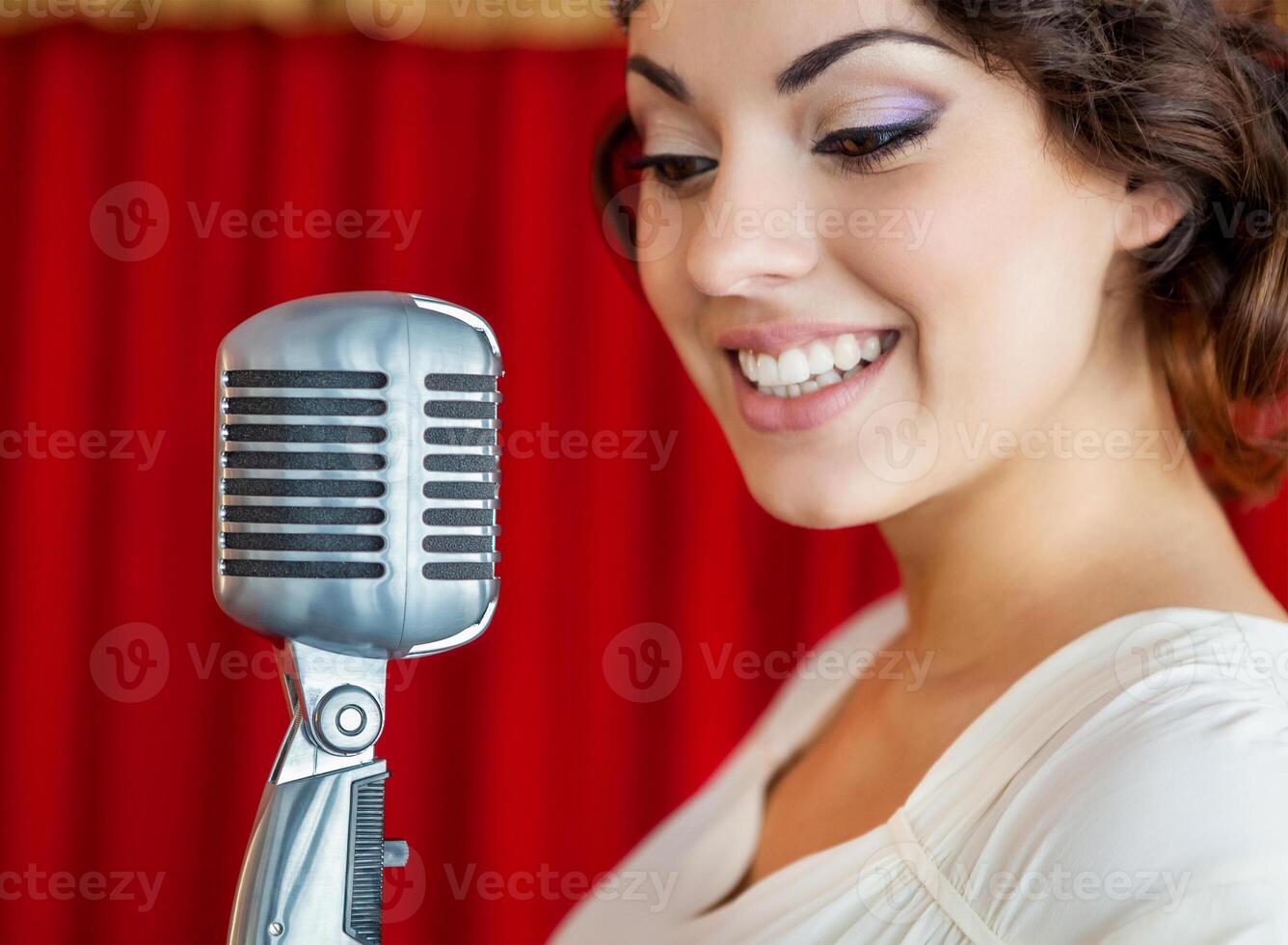 Beautiful woman singing with the microphone photo