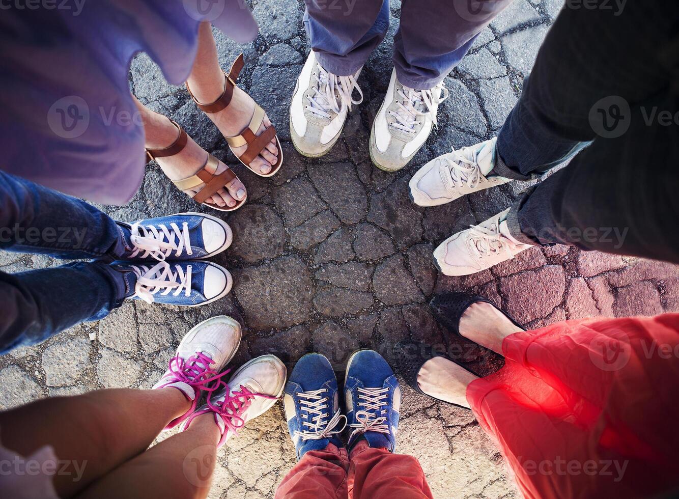 Group of friends with their legs in a complete circle photo