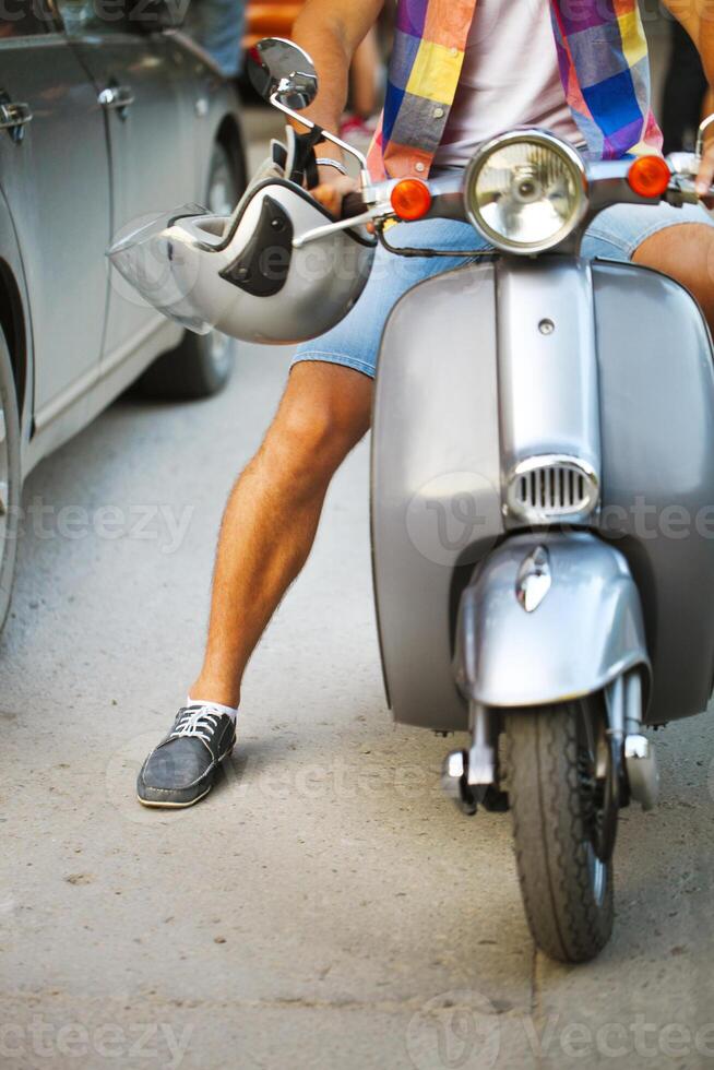 Young man riding scooter along the street photo