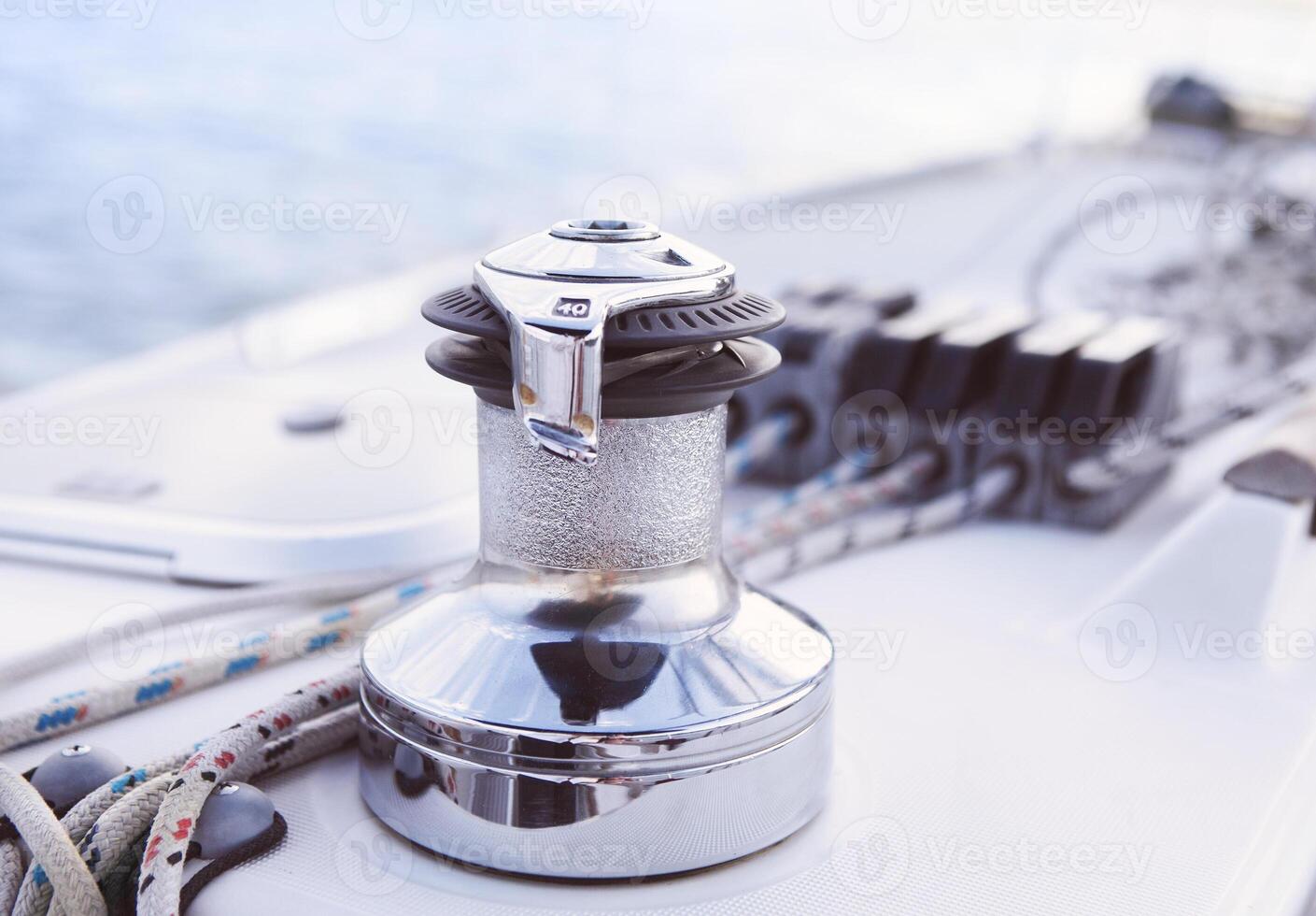 Sailboat detailed parts. Close up on winch and rope of yacht over blue sea photo