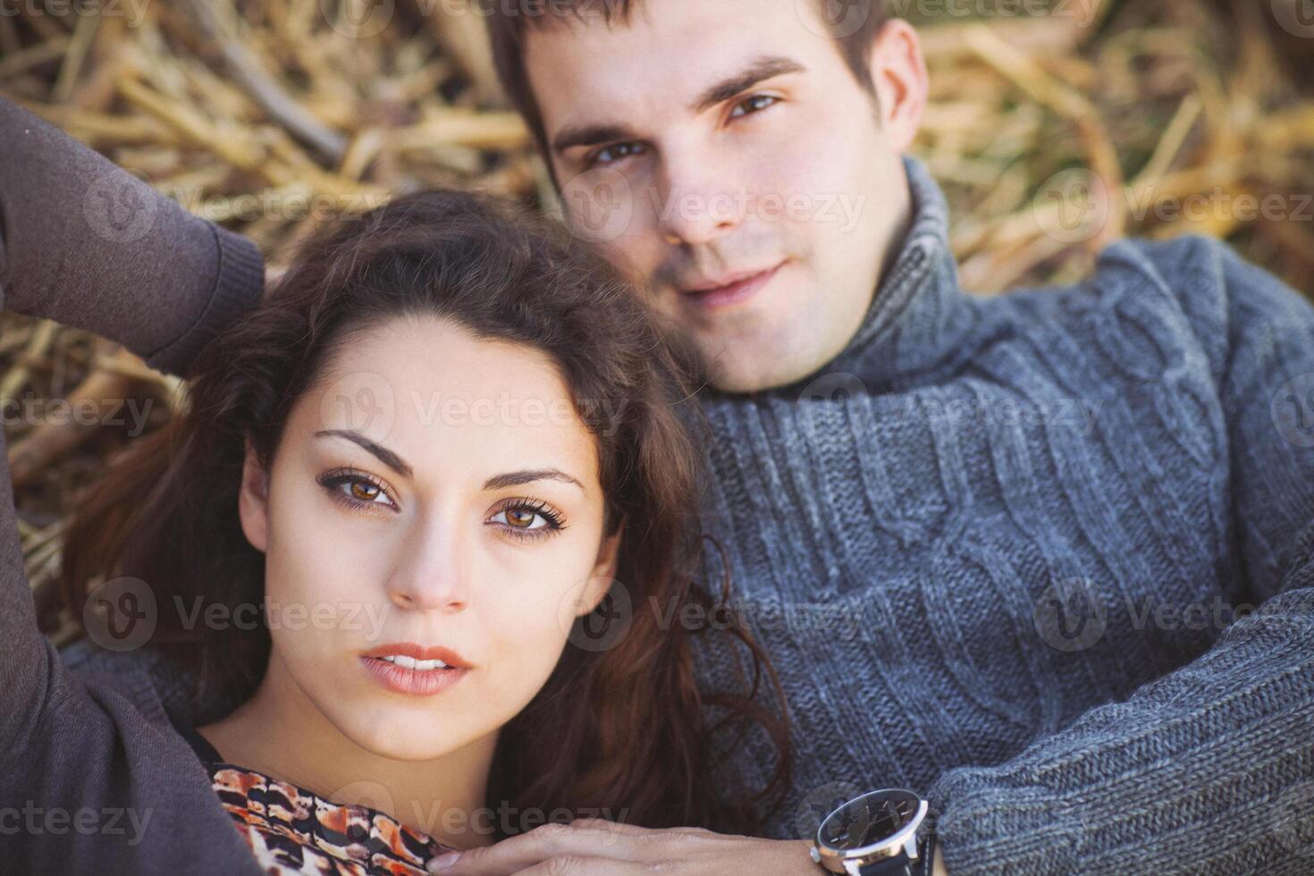Young couple lying down smiling at autumn background photo