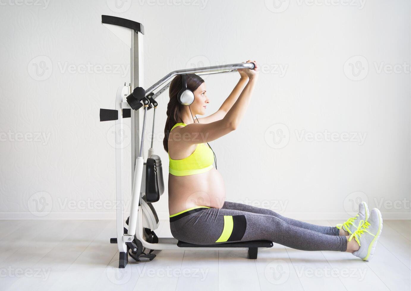 One young pregnant woman doing fitness exercises photo