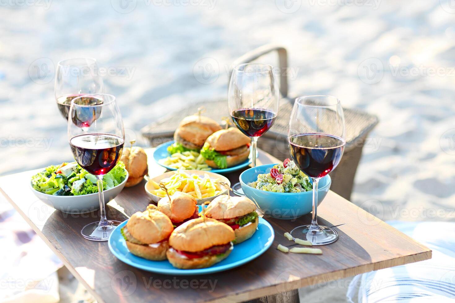 Picnic table with red wine glasses photo