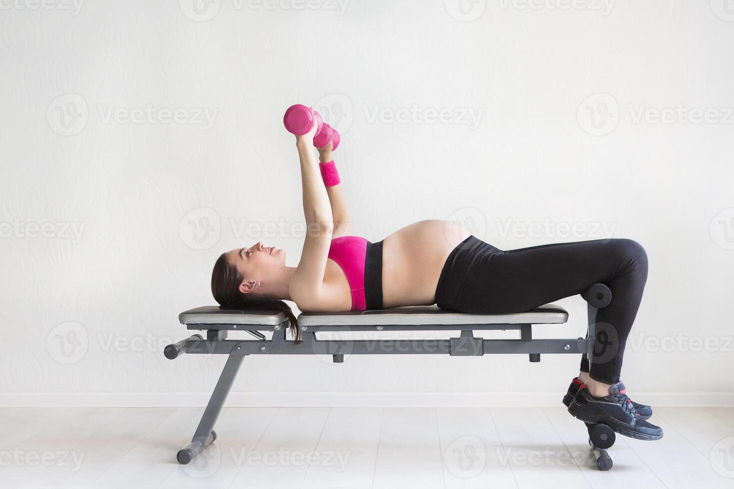 One young pregnant woman doing fitness exercises photo