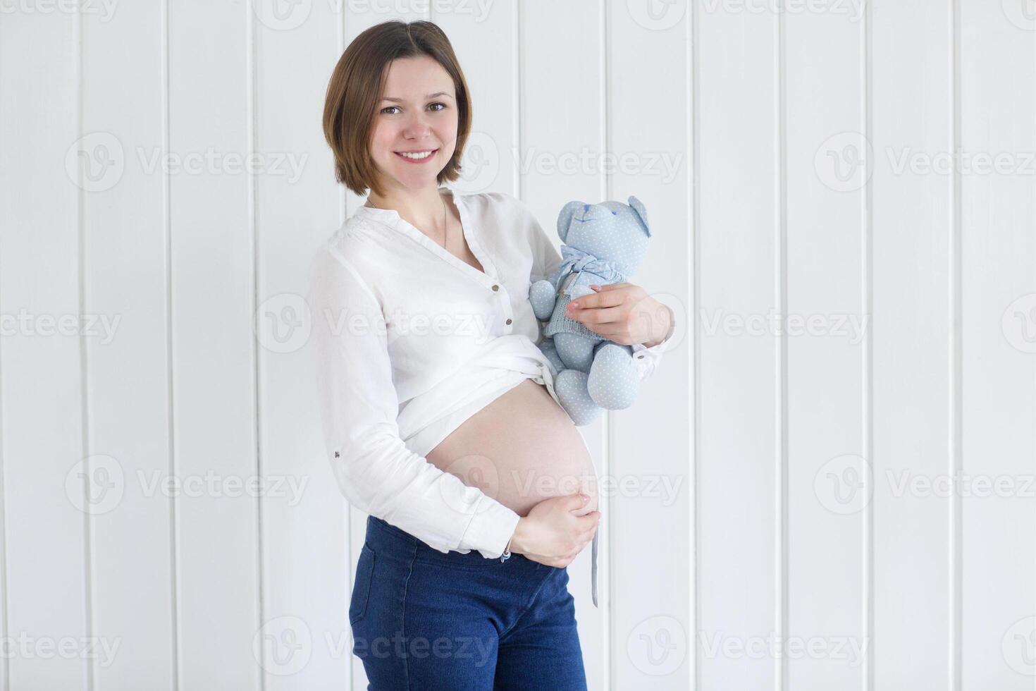 Pregnant woman holding a teddy bear photo