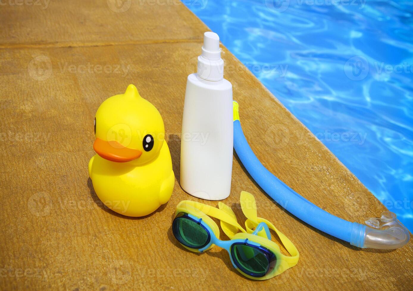 Suncream, snorkel, goggles and yellow rubber duck photo