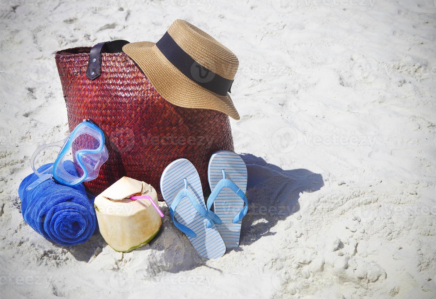 Straw hat, wather mask, beach towel, flip flops with beach bag and coconut cocktail photo