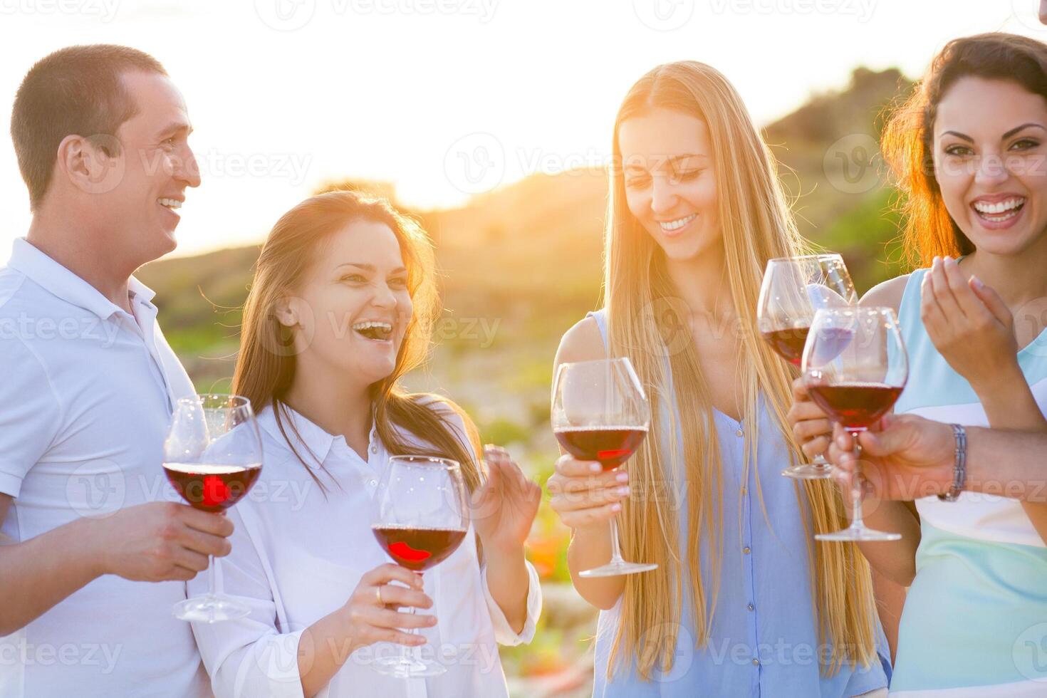 People holding glasses of red wine making a toast photo
