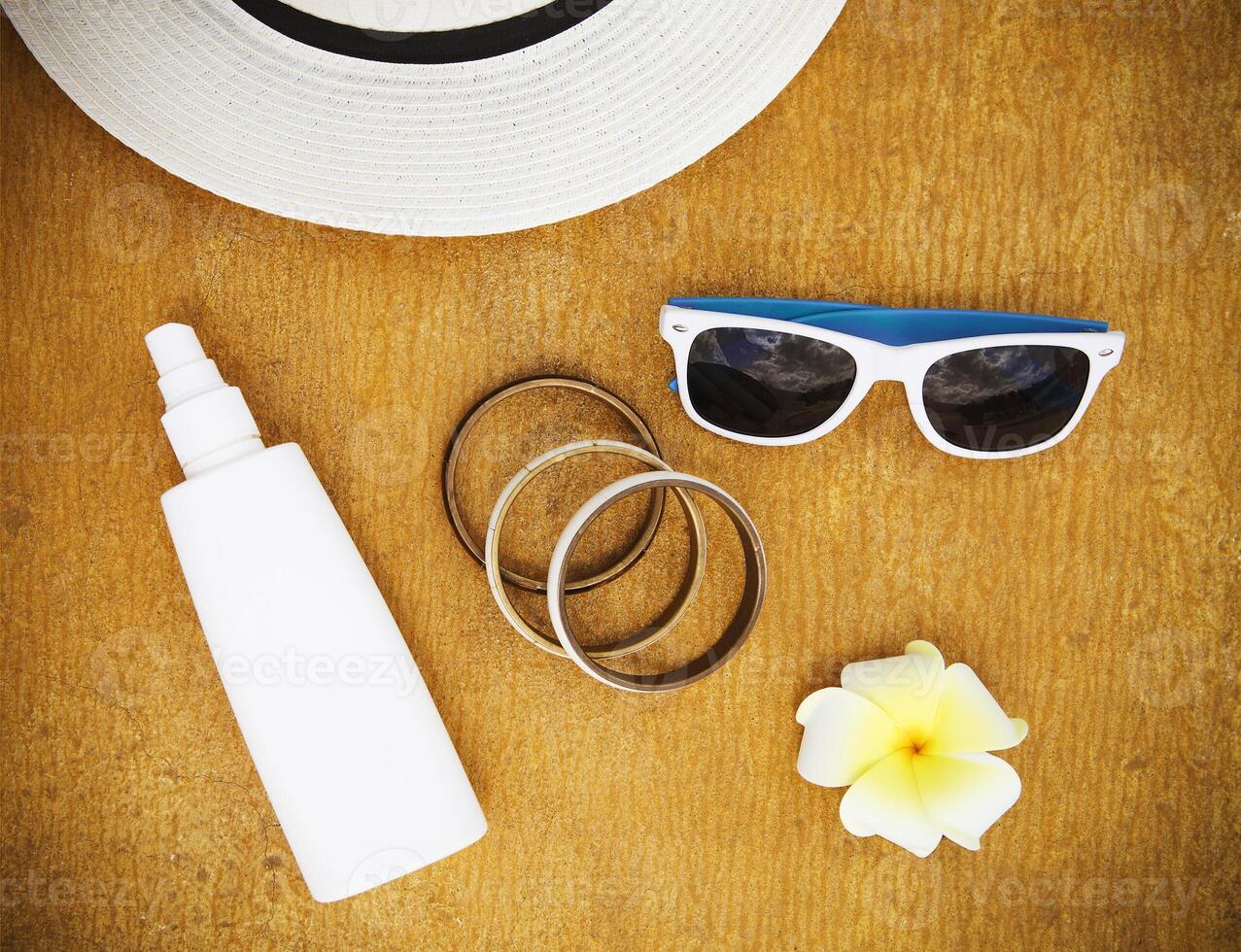 Fashionable clothes sunglasses, stylish bracelets, hat, cream for beach holiday photo