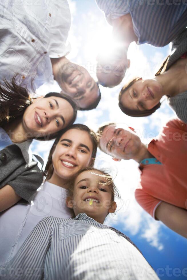 Group of happy smiling friends against blue sky photo