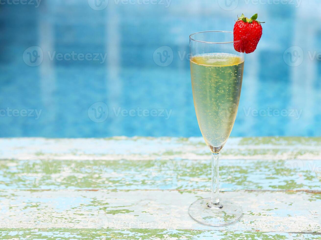 Champagne glass with strawberry on turquiose background photo