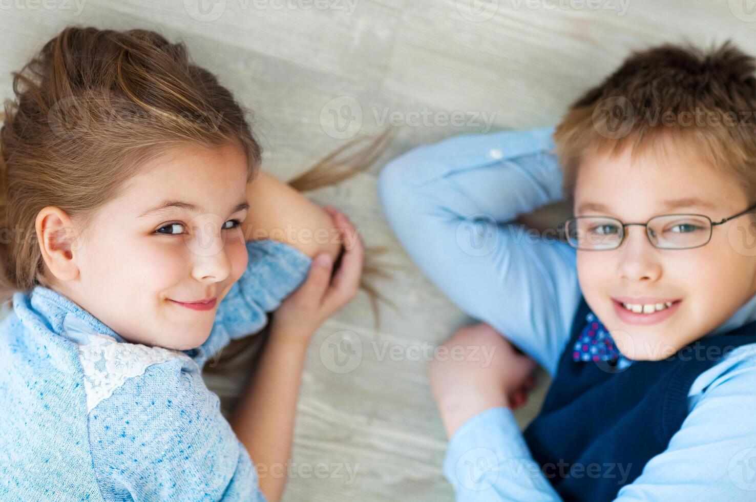 Happy kids are lying together on the floor photo