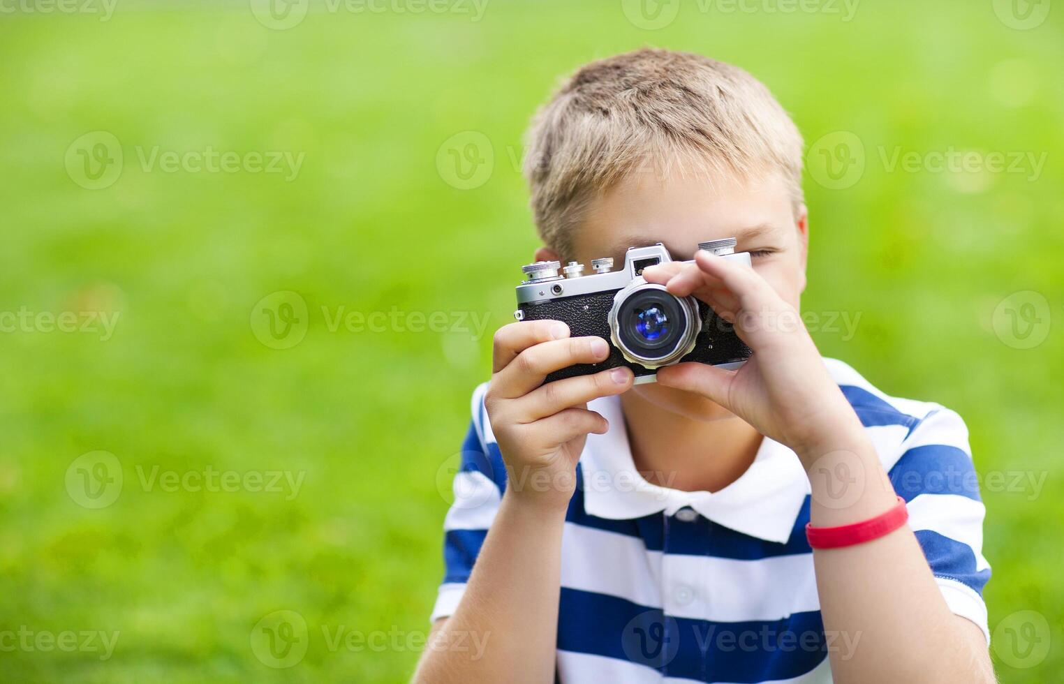 Happy smiling little boy with retro vintage camera photo
