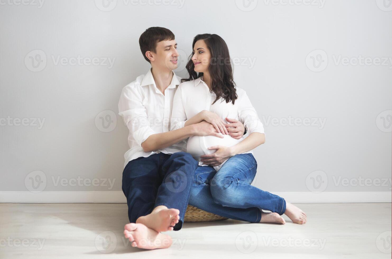 Pregnant woman and young man together indoors photo