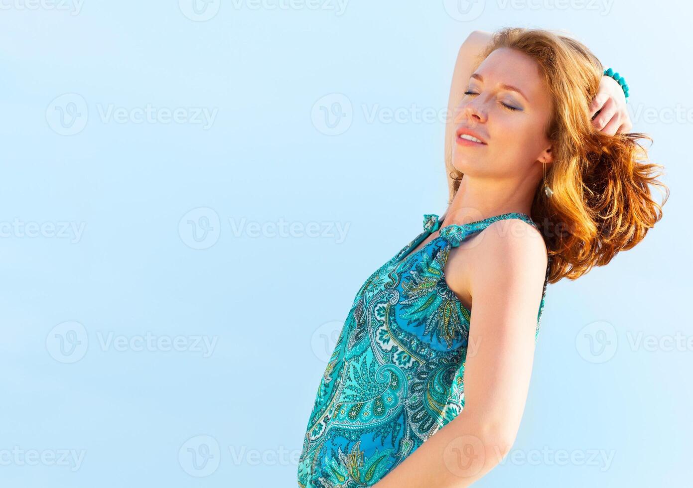 Portrait of the beautiful young woman with fluttering red hair photo