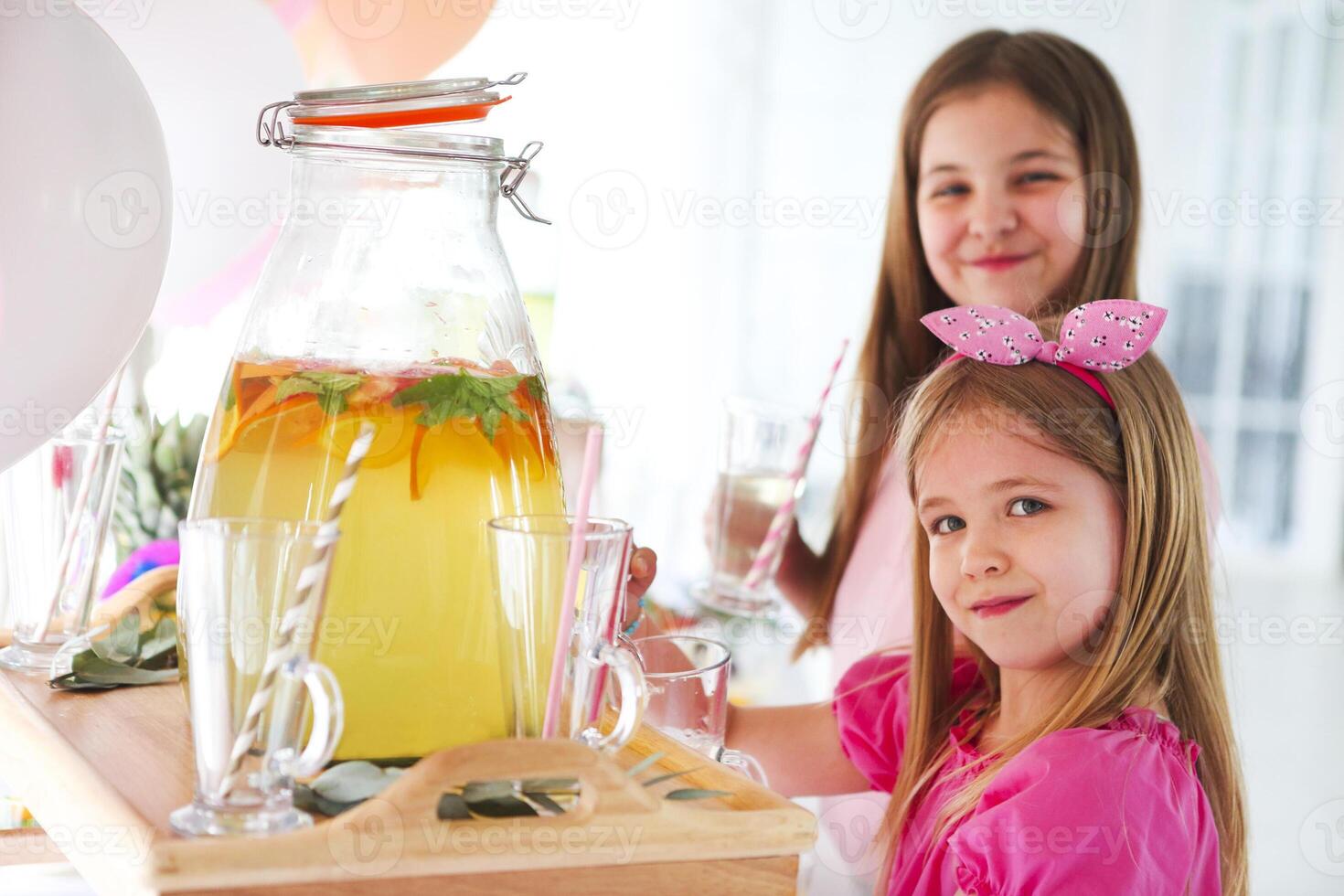Kids by the candy bar with cake and citrus lemonade photo