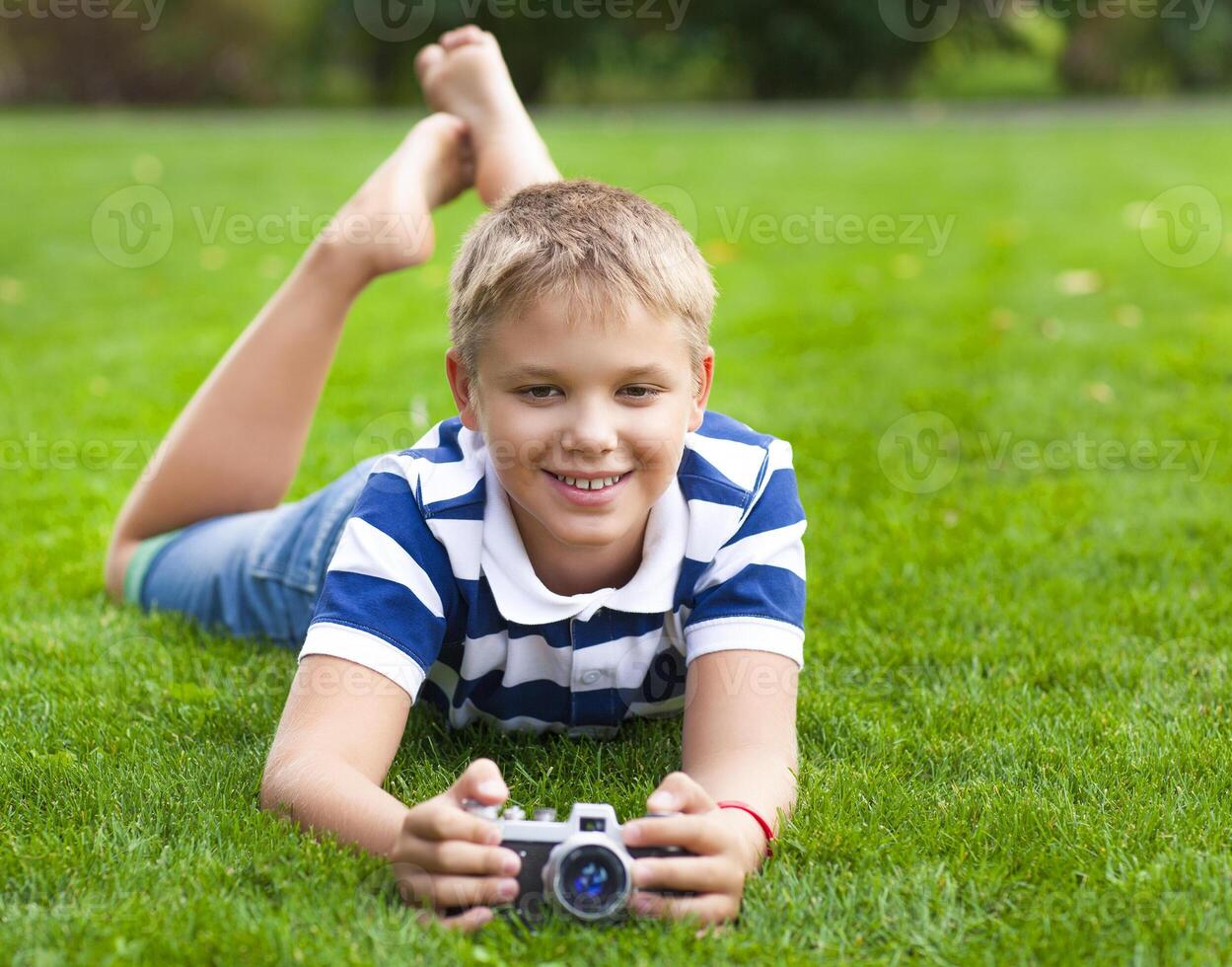 Happy smiling little boy with retro vintage camera photo