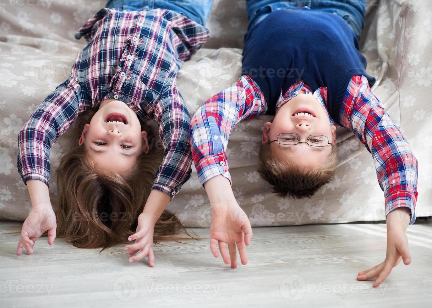 Happy children upside down on the sofa photo