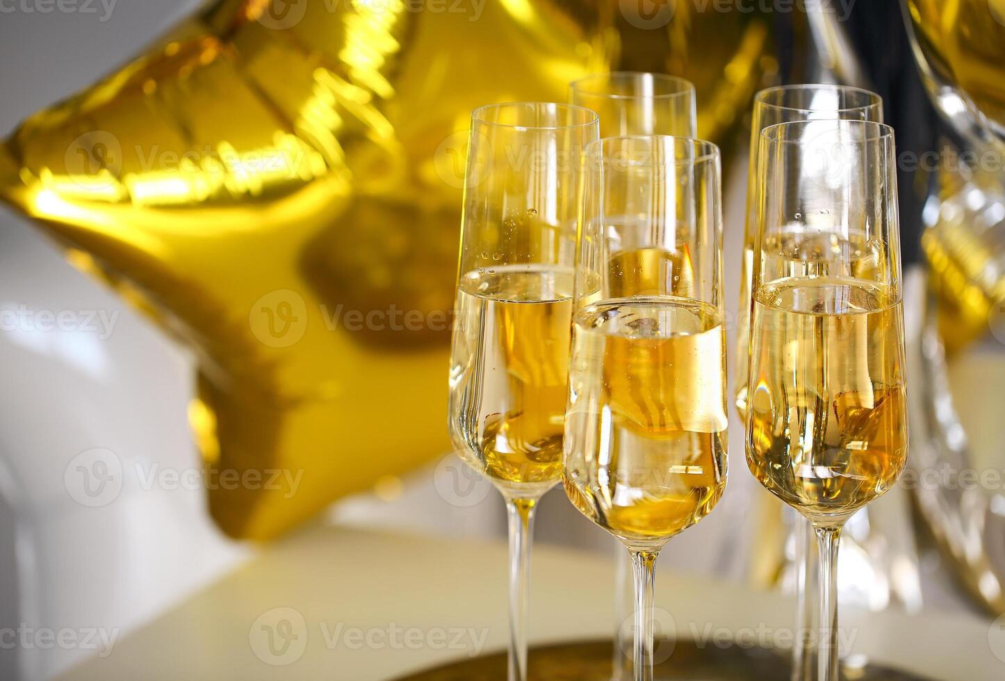 Close up of shiny glasses of champagne over party background photo