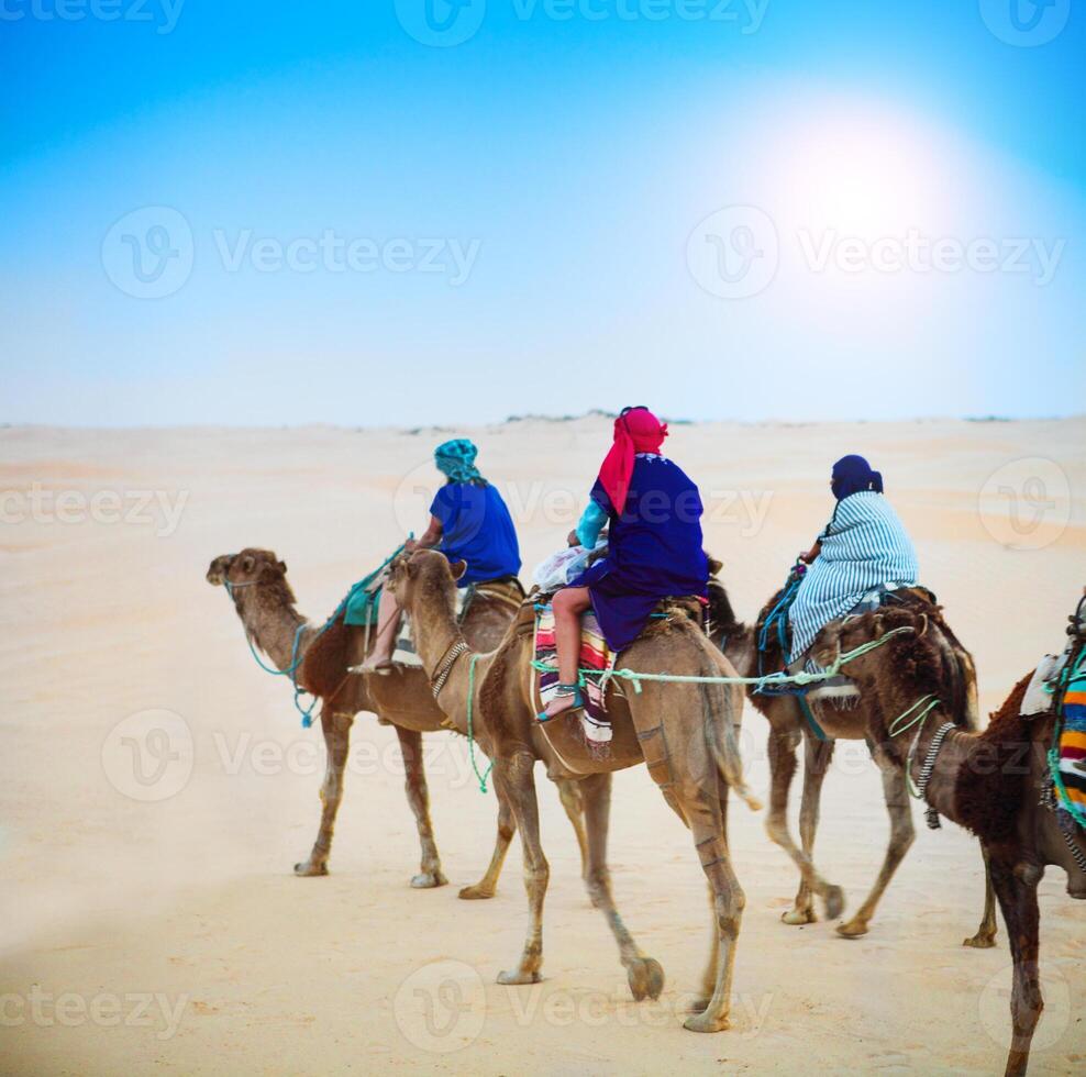 Group of tourists going for a desert camel safari. Sahara landscape photo