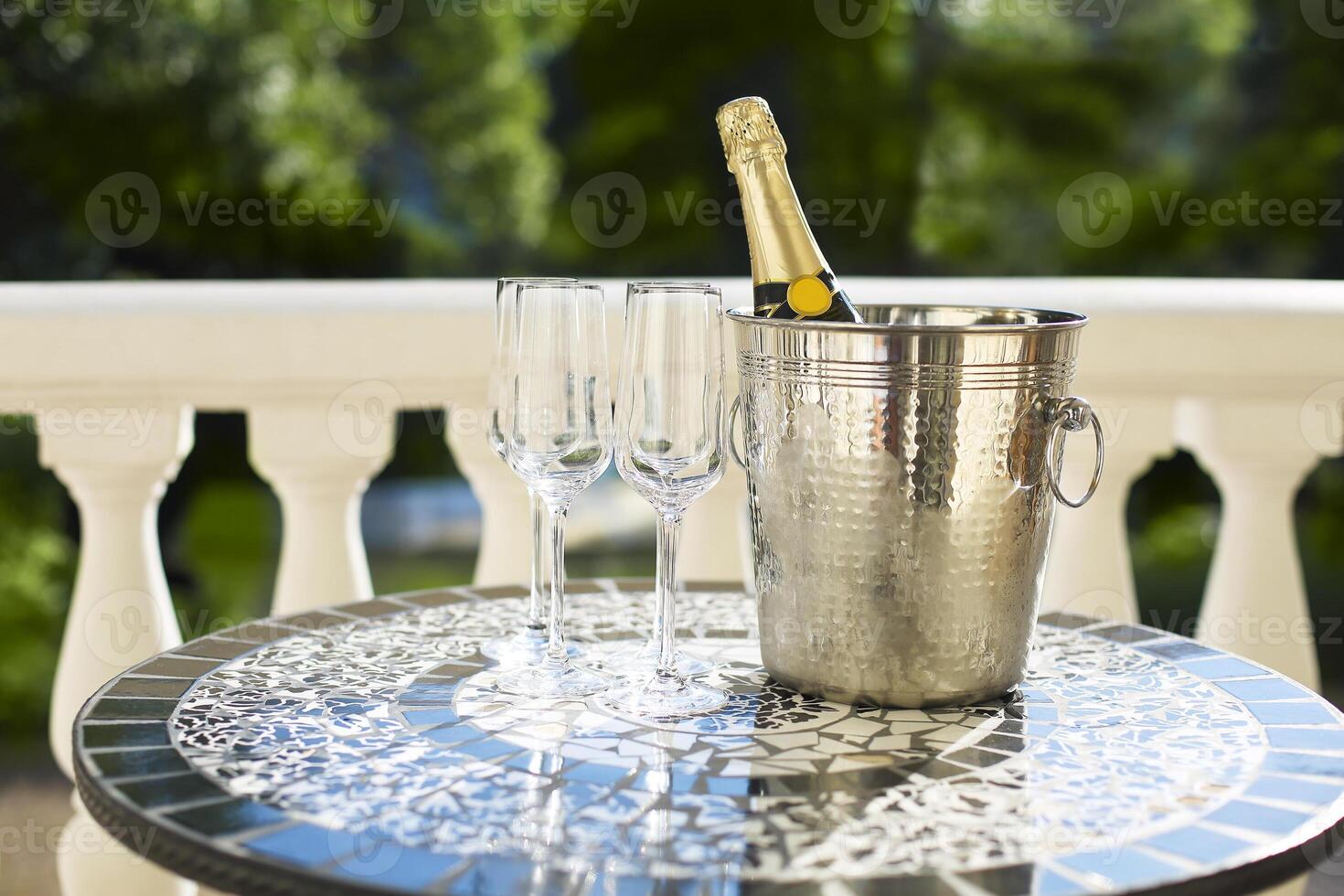 Champagne bottle and four flutes on the table photo