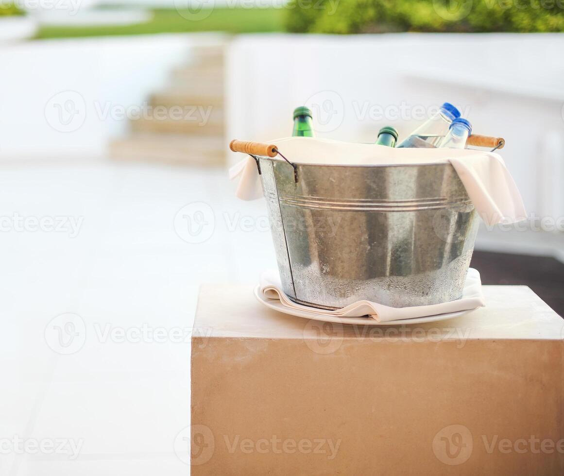 Ice bucket with mineral water outdoors photo