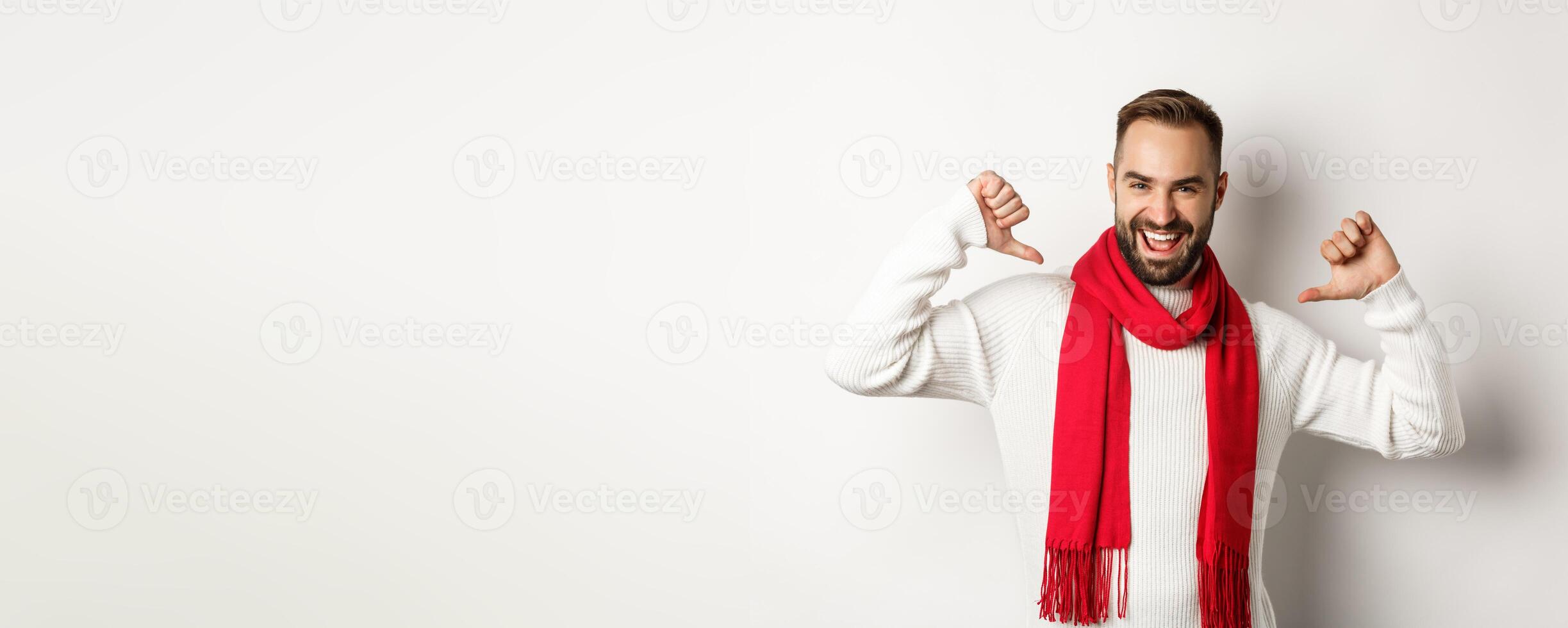 Winter holidays and shopping concept. Confident bearded man pointing at himself and smiling satisfied, celebrating christmas in red scarf and sweater, white background photo