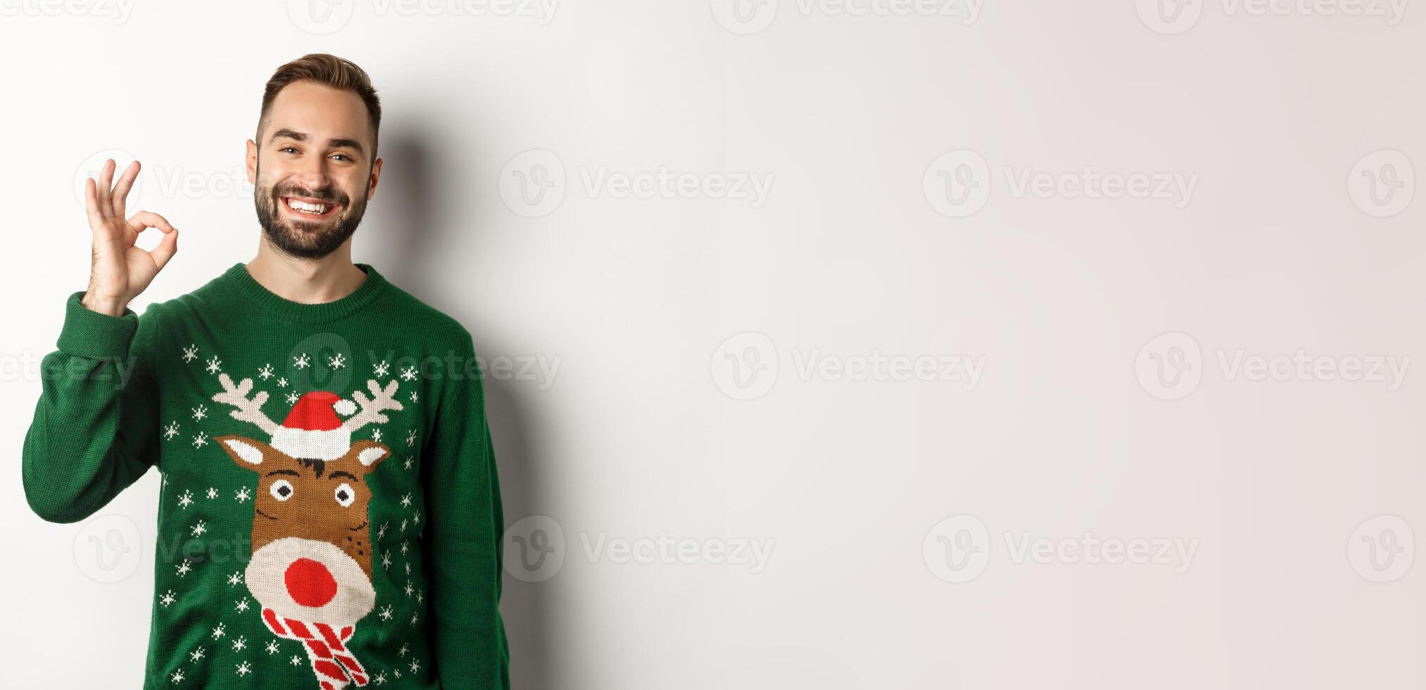 Winter holidays and christmas. Happy bearded man showing okay sign and smiling, approve or agree, praising something good, standing over white background photo