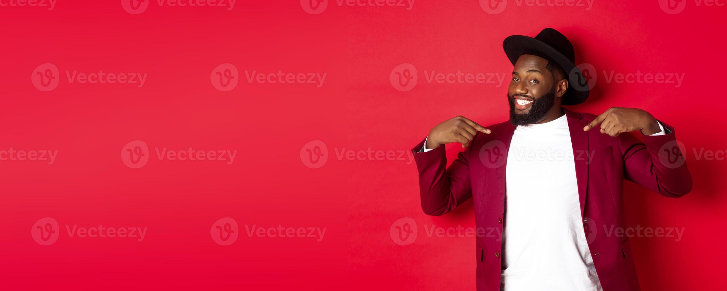 Christmas shopping and people concept. Handsome Black man pointing at himself, going on party, standing confident against red background photo