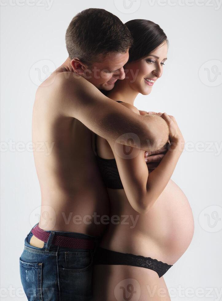 Young man and pregnant woman in studio photo