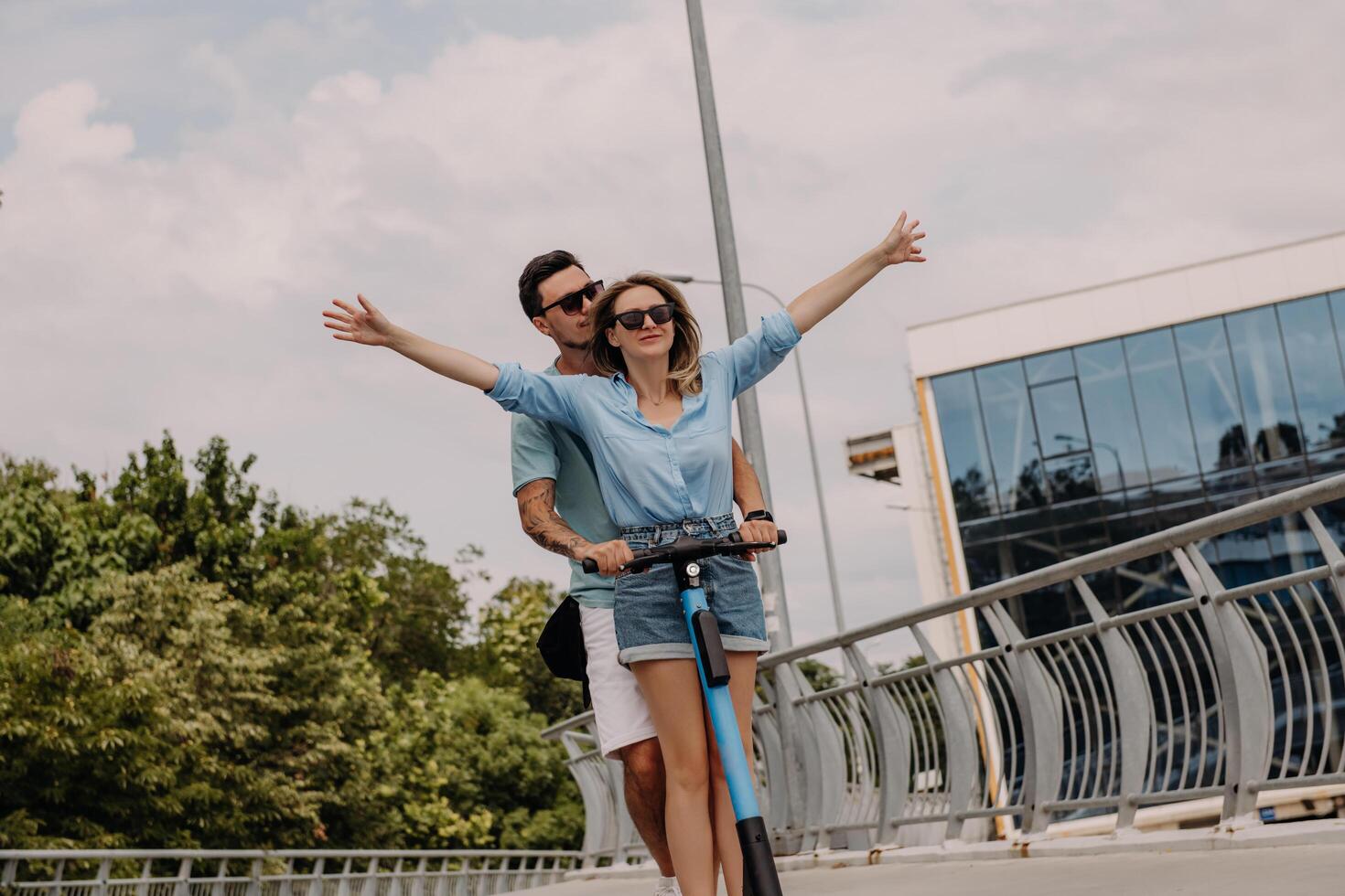 Beautiful young couple enjoying fun time together while riding electric scooter outdoors together photo