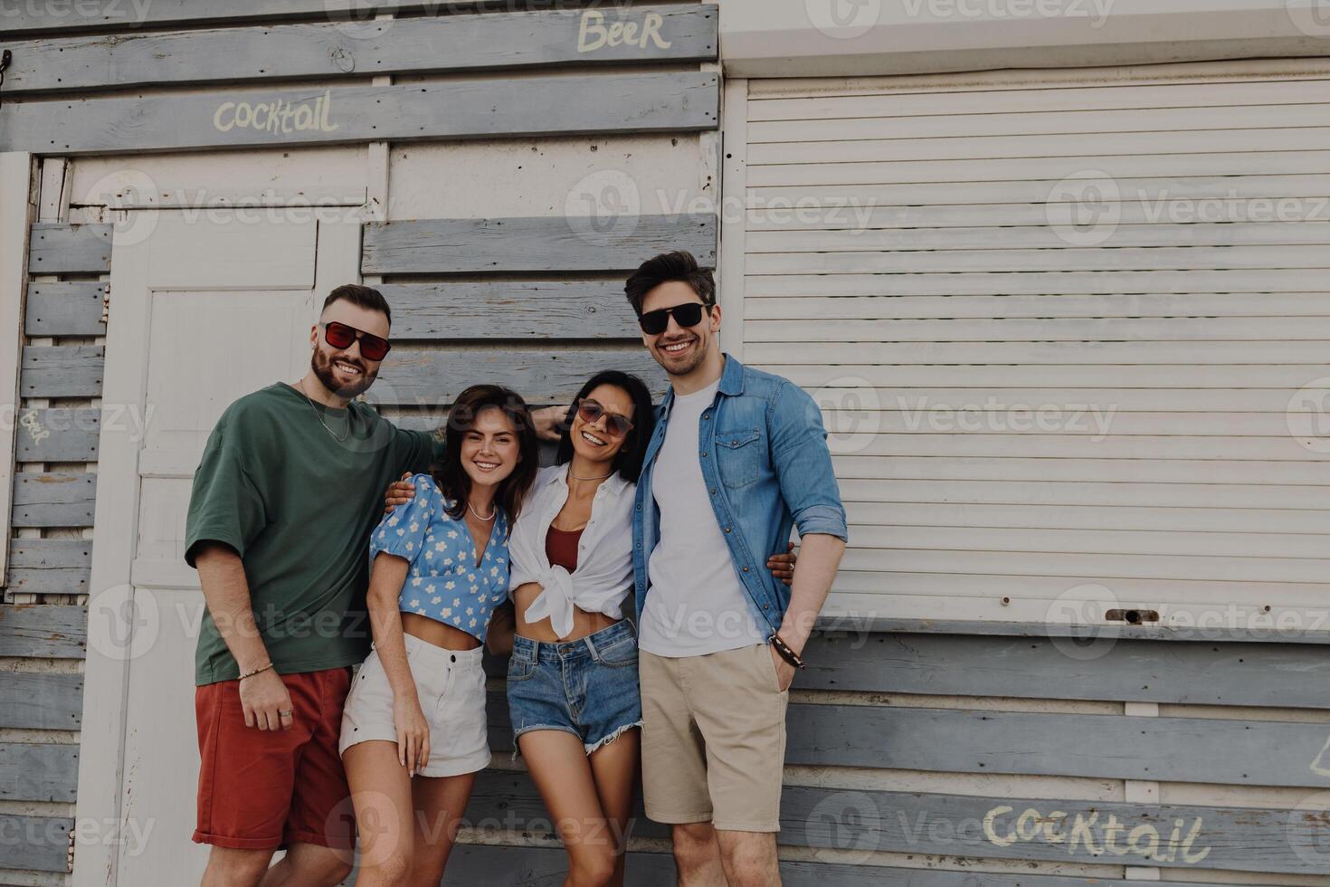 Group of joyful friends bonding and smiling while spending summer day outdoors together photo