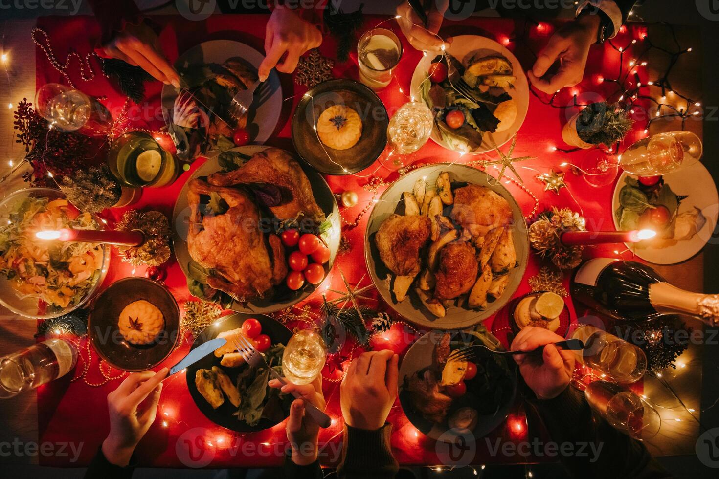 Top view of people enjoying variety of Christmas dishes while having holiday dinner at the decorated table photo