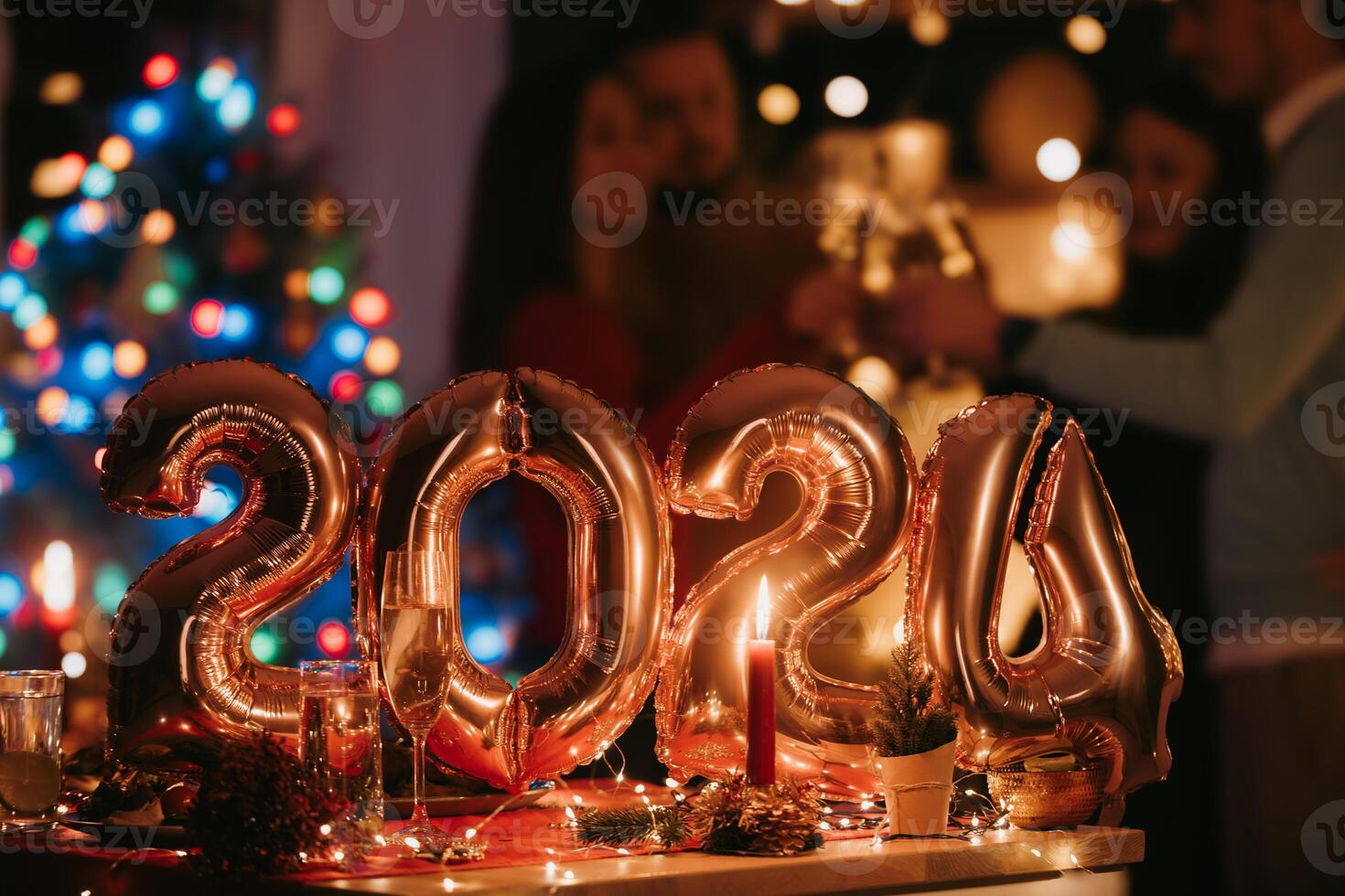 Happy young people celebrating New Year with golden balloons in shape of number 2024 on foreground photo