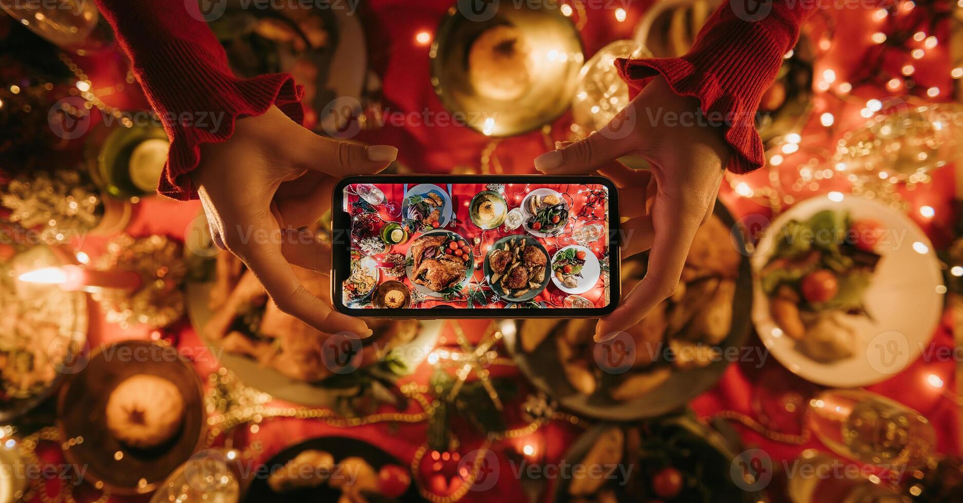 Top view of woman photographing decorated Christmas table with variety of festive dishes photo