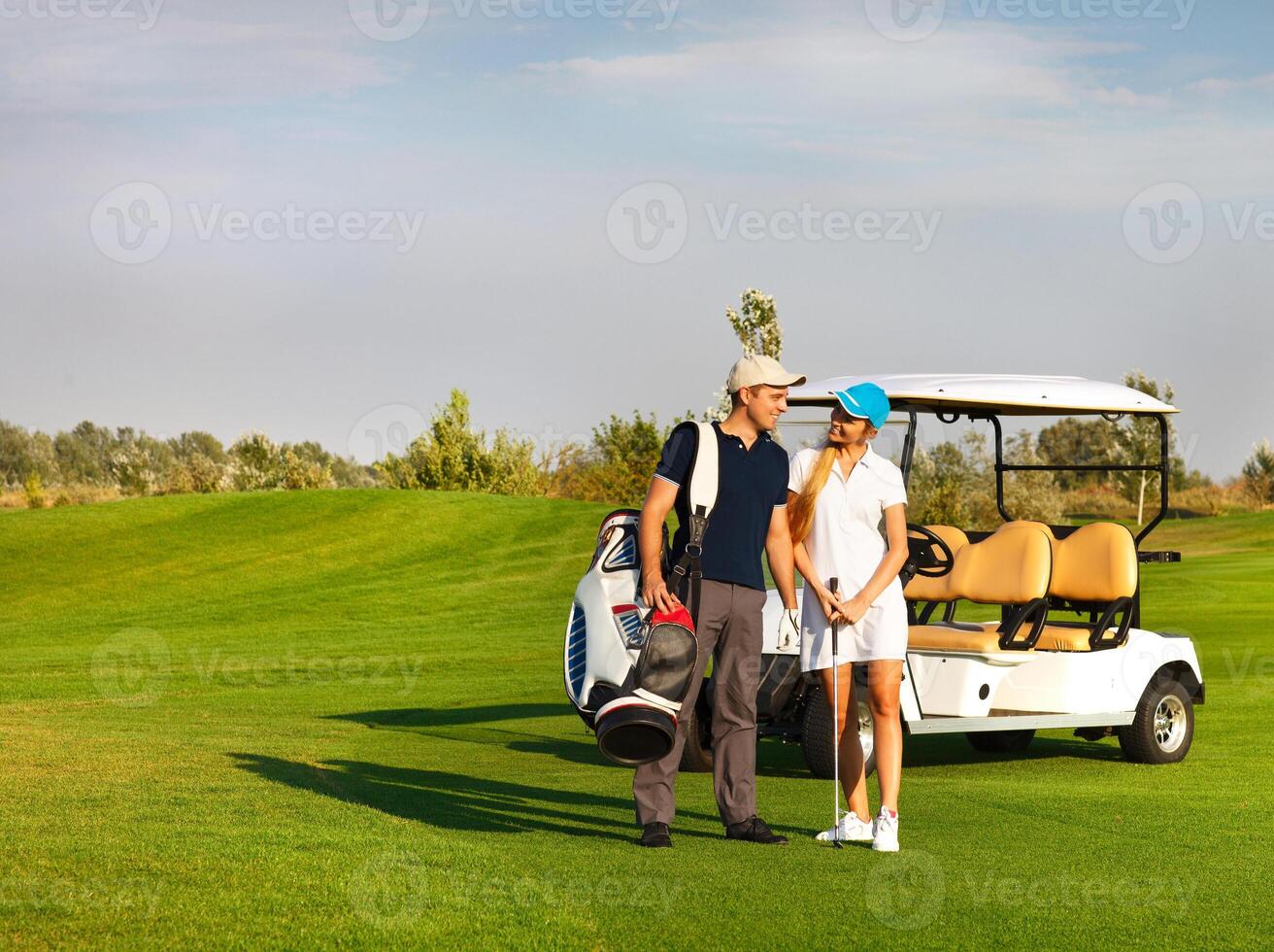 Young sportive couple playing golf on a golf course photo