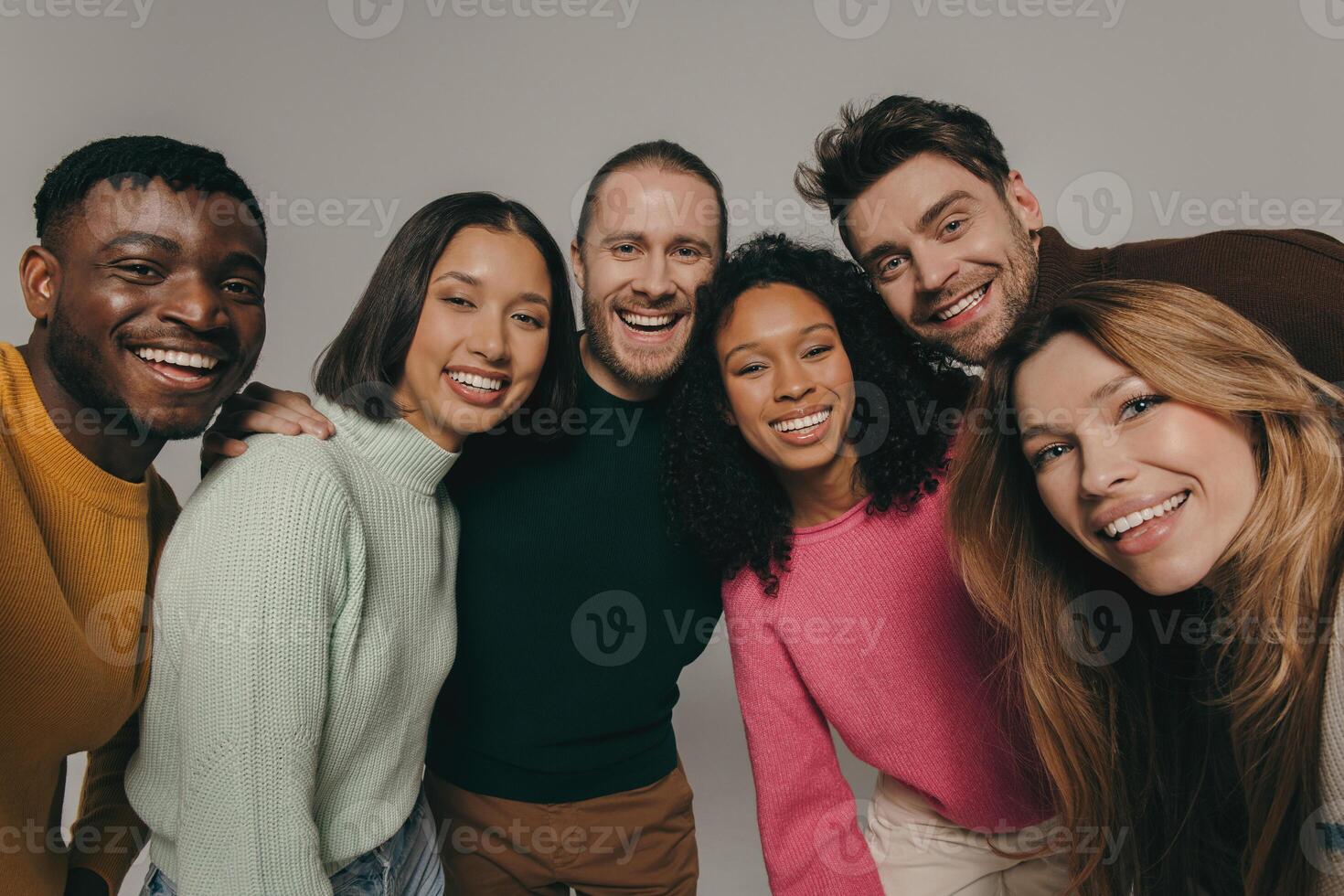 Joyful young people bonding and smiling while making selfie on beige background together photo