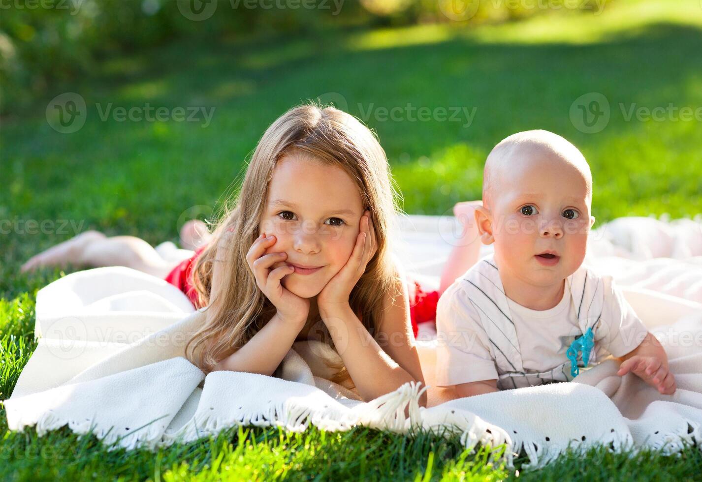 Two children on green meadow and smile photo