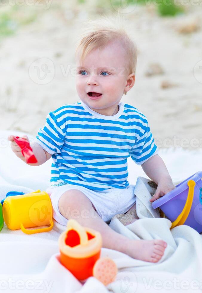 Baby girl playing with beach toys on the beach photo