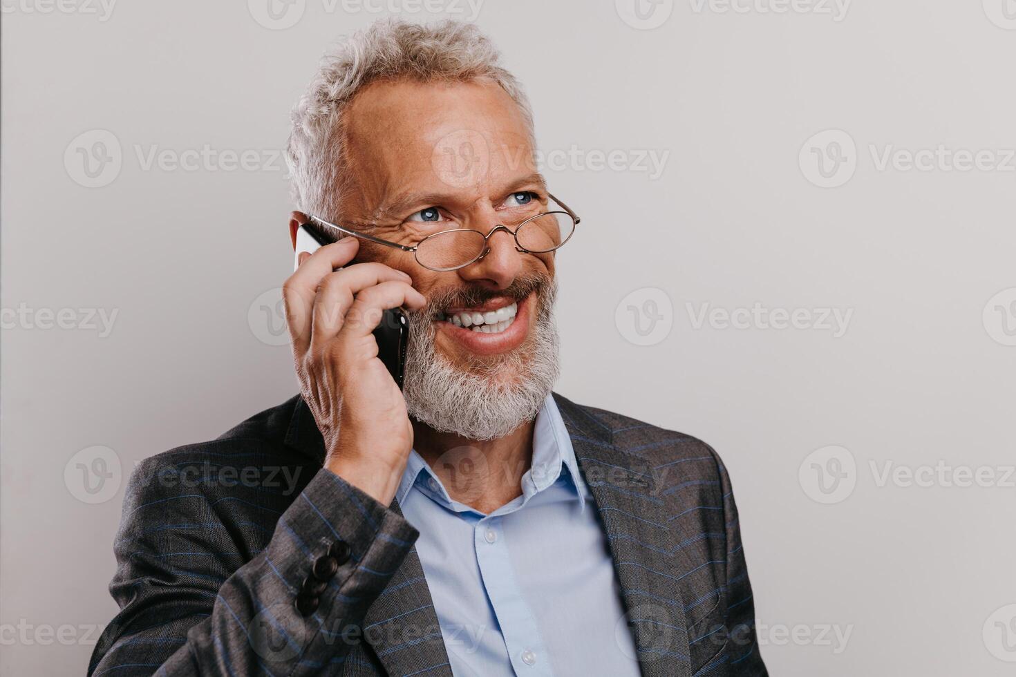 Portrait of happy mature businessman in formalwear texting on smart phone against white background photo