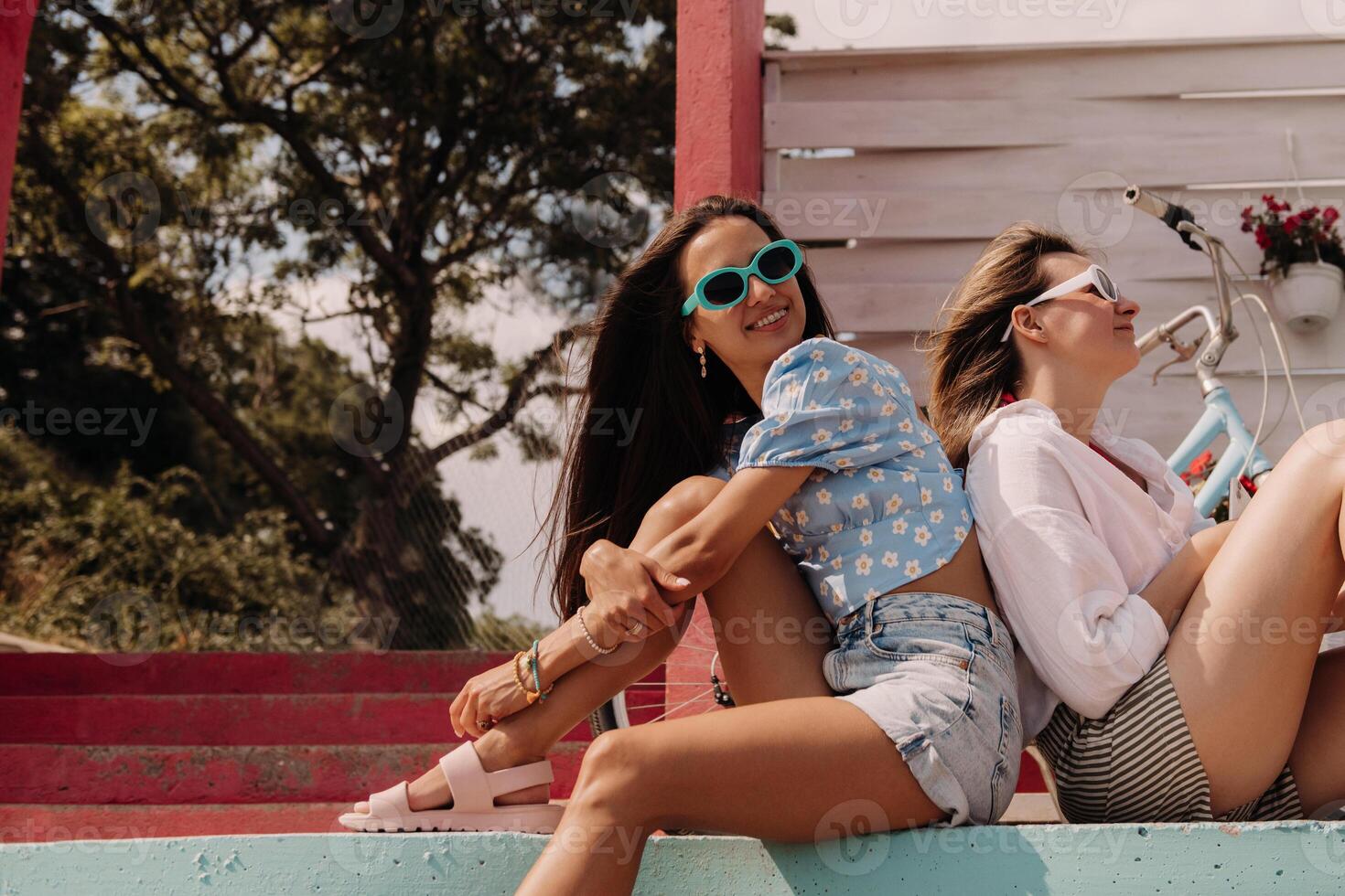 Two joyful young women looking relaxed while enjoying summer day outdoors together photo