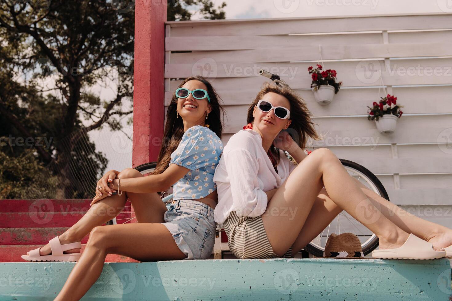 Two joyful young women smiling while enjoying summer day outdoors together photo