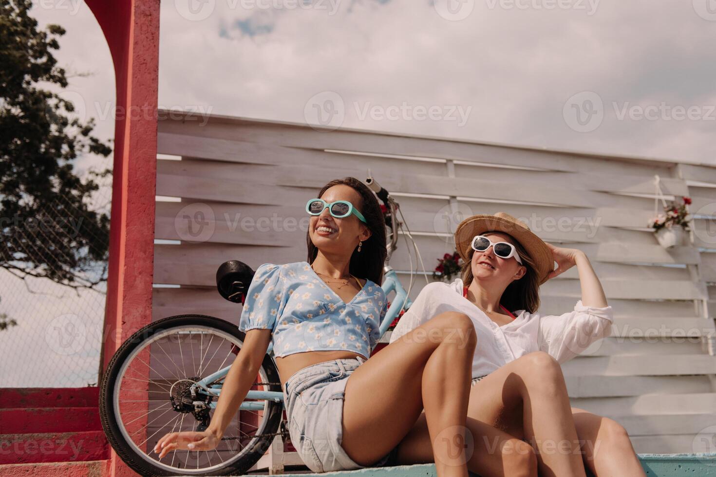 Two happy young women looking relaxed while enjoying summer day outdoors together photo