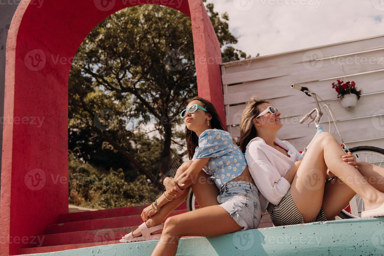 Two beautiful young women looking relaxed while enjoying summer day outdoors together photo