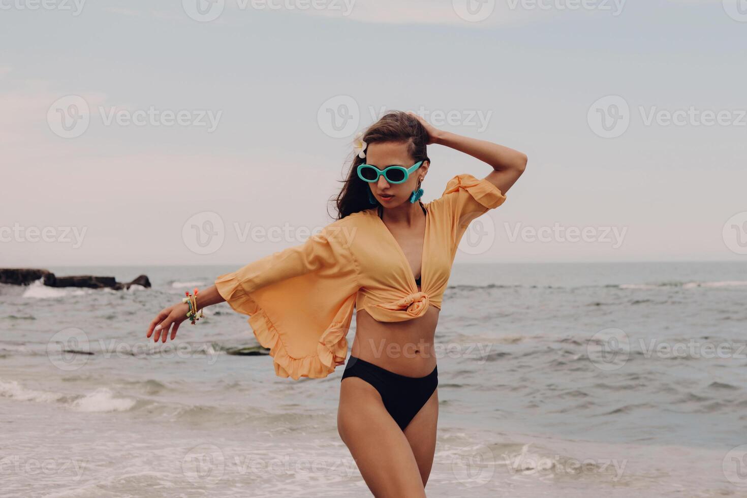 Attractive young woman in boho styled crop top enjoying summer day on the beach photo